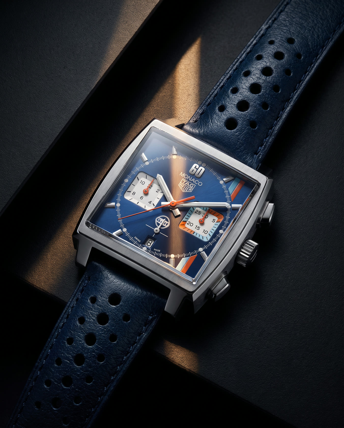 Blue luxury chronograph watch lit with warm cinematic highlights