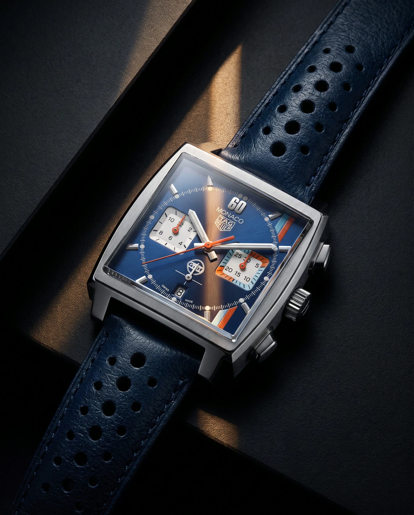 Blue luxury chronograph watch lit with warm cinematic highlights