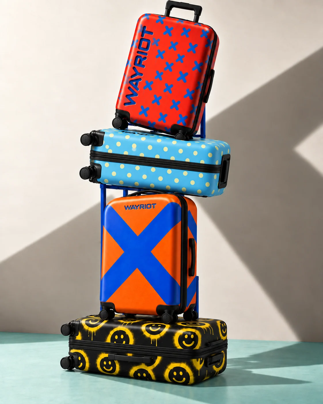 Four WAYRIOT suitcase designs stacked against ivory and mint